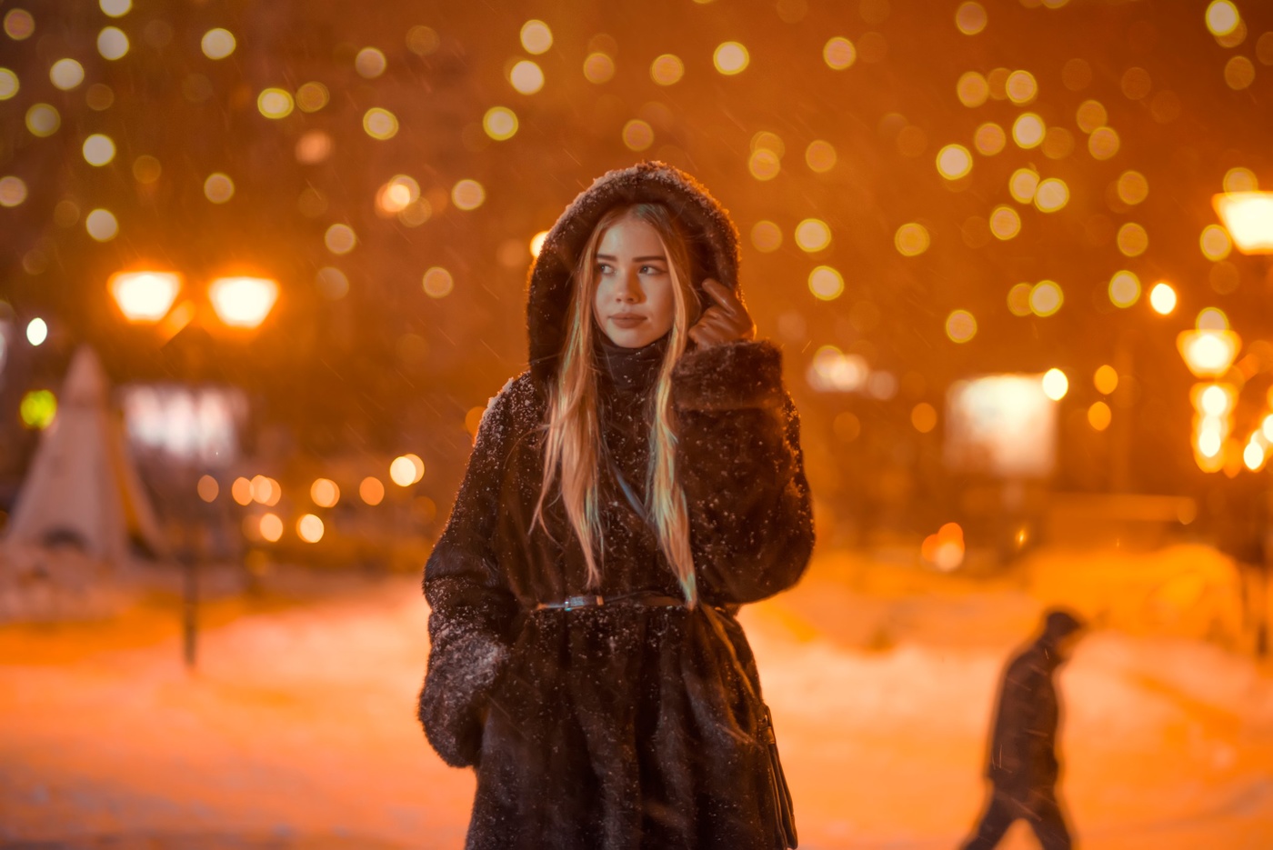 Сексуальная девушка с пуховым платком позирует ночью на улице 