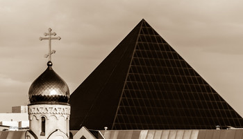 Символы в клеточку / Купол церкви с крестом рядом с крышей торгового комплекса.