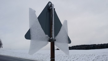 &nbsp; / Looking at the back side of the traffic sign you can understand what happened here. The snow had been sticking to the back of the traffic sign and before freezing it partially melted creating a thin ice layer. During the next day this ice had been melting while still sticking a little bit to the downside. And this way the angel spread its wings!