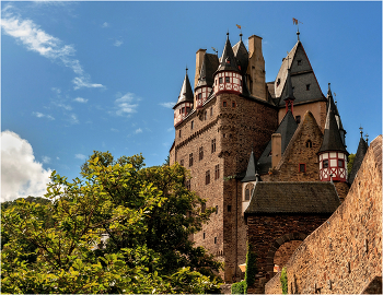 Замок Эльц / Замок Эльц (нем. Burg Eltz) — замок в земле Рейнланд-Пфальц близ Виршема в долине реки Эльцбах, отделяющей Майфельд от предгорьев Айфеля. Замок Эльц считается наряду с дворцом Бюрресхайм единственным сооружением в Айфеле, которое никогда не подвергалось захвату и не было разгромлено. Замок уцелел даже во время войн XVII и XVIII вв. и потрясений Французской революции. Замок в долине речушки под названием Эльц был построен предположительно в XII веке. Замок сохранился и до настоящего времени. С трёх сторон замок окружён рекой и возвышается на скале высотой в 70 метров. Вокруг замка замечательный ландшафт.