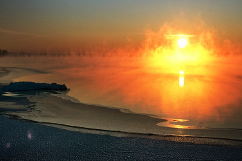 утомлённое солнце / зимний закат в тихую погоду на озере, которое парит