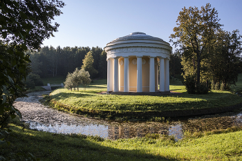 Храм Дружбы. / Павильон «Храм дружбы» (1780—1782) был задуман Павлом Петровичем и Марией Фёдоровной, как ответный дар Екатерине II за павловские земли. Архитектор Ч. Камерон спроектировал храм-ротонду, охваченную кольцом каннелированных колонн дорического ордена и поставленную на полуострове, образованном излучиной реки. Первоначально в Храме находилась большая мраморная статуя Екатерины II, но в 1791 году её подарили графу И.Г.Чернышеву и в 1792 году установили алебастровую фигуру императрицы в образе Цереры. Храм Дружбы предполагалось использовать для завтраков и ужинов в парке, поэтому на противоположном берегу Славянки была построена кухня в виде сельского домика (разобрана в начале XIX века).