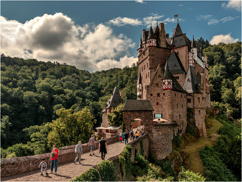 Замок Эльц / Замок Эльц (нем. Burg Eltz) — замок в земле Рейнланд-Пфальц близ Виршема в долине реки Эльцбах, отделяющей Майфельд от предгорьев Айфеля. Замок Эльц считается наряду с дворцом Бюрресхайм единственным сооружением в Айфеле, которое никогда не подвергалось захвату и не было разгромлено. Замок уцелел даже во время войн XVII и XVIII вв. и потрясений Французской революции. Замок в долине речушки под названием Эльц был построен предположительно в XII веке. Замок сохранился и до настоящего времени. С трёх сторон замок окружён рекой и возвышается на скале высотой в 70 метров. Вокруг замка замечательный ландшафт.