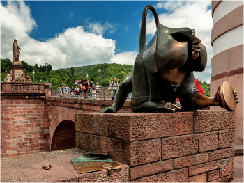 Старый мост г. Гейдельберг ( нем. Heidelberg ) — город в Германии / На южной стороне моста находится созданная скульптором Гернотом Румпфом бронзовая скульптура мостовой обезьяны, которая символизирует существовашую здесь во второй половине 15 века &quot;Обезьянью башню&quot;. Входящих в город путешественников, &quot;Обезьянья башня&quot; приветствовала едкой насмешкой: барельефом обезъяны, держащей в одной руке зеркало, а другой держащейся за зад. Была такая надпись &quot;Ну чего уставился и глазеешь? Не видел никогда старую обезъяну? Иди скорей в Гейдельберг, Там ты увидишь еще более интересные вещи.&quot; Сейчас эта надпись тоже присутствует. Она выполнена на медной дощечке и установлена на парапете рядом с постаментом.