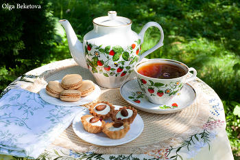 Чай в саду / чашки и чайник на круглом столике в саду