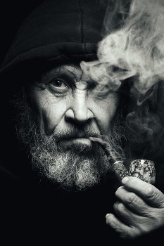 Портрет на дуршлаг (читайте описание) / Да, именно на дуршлаг. Фотографировал в подвале. Июнь 2025 года. Покровск (Красноармейск) Донецкой области. Одно из самых острых направлений на Донбассе. 
Заинтересовал?!) Ну тогда вот моя история!

Идея фотосессии родилась спонтанно. Я и ещё несколько человек прятались в подвалах. Это южная сторона города, наиболее обстреливаемая часть Покровска. На тот момент мы уже 7 месяцев прятались по подвалам. Жил я там с совершенно не знакомыми людьми, но нас «сдружила» война. И вот как-то один из моих товарищей по несчастью, увидев на банке с консервой, изображение моряка, с бородой и трубкой, говорит: 
-Жека! А смогёшь и мне такой портрет сделать?!
Сказано это было с максимальным ехидством. Я когда раньше рассказывал про свои съёмки в студии, участия в конкурсах, победы и достижения, он (дядя Коля, так я к нему обращался), ёрничал и язвил. Типа, ну да, ну да! Расскажи. Все вы на словах фотографы профессионалы!
И я уже тогда думал, как бы тебе доказать…

И вот однажды, в Минуты затишья, на развалинах соседского дома, мне на глаза попадается большой (40-45 см. в диаметре) дуршлаг. И сразу же в голове вспомнил слова известного Питерского фотографа Игоря Сахарова:
-Ну что вы все ноете, что нет оборудования! Вот возьму когда-то цинковое ведро и одну вспышку и сделаю портрет! Главное понимать и управлять светом! 

А я сразу решил, что ведь этот дуршлаг, практически готовая портретная тарелка. Сделал отверстие для вспышки (а у меня от всей моей студии, помимо фотоаппарата с объективами в сумке, оказались две старенькие но рабочие вспышки Yongnuo, остальное все сгорело). Обклеил скотчем. Закрасил нитроэмалью серебрянки. Из крышки пластикового ведра сделал отражатель. И обтянул полиэтиленовым пакетом, что-то типа рассеиватель получилось. Вспышку крепил скотчем.

Штативом для моего журавля послужила телескопическая швабра (чтоб можно было регулировать высоту). А перекладиной был фрагмент удочки. Все это я тоже нашел на руинах соседского дома. 

Вторым, заполняющим светом, стал старый зонт. Я его предварительно задул все с того же баллончика с серебрянкой. Худо-бедно вышел фотозонт. Он крепился на кусок рейки. 

Контровым светом мне послужили два куска пенопласта надетые на алюминиевые трубки. 
Все мои «студийные осветительные приборы» крепились резиновым жгутом к баклажкам с водой. Худо бедно, но все держалось. Как говорится, я тебя слепила из того что было.

Фоном был остаток рулона агроволокна (если я правильно понял). Как раз был темно коричневого цвета, то что нужно. 

Сама фотосессия проходила в подвале дома в котором мы находились. Для понимания, одной рукой я отодвигал и придерживал верёвку, на которой сушилось бельё (на улице в целях безопасности мы не сушили вещи), а другой рукой фотографировал. Очень экстремальная съёмка получилась. Врать не буду, в день съёмки обстрела, ну по крайней мере по нам, не было. 

Строго не судите, компьютер сгорел, обрабатывал на телефоне.