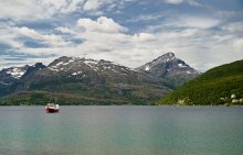 Типичный норвежский пейзаж с горами фьордом и рыбацкой шхуной. / Северная Норвегия