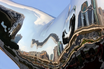 В танце материи / Зеркальная рука перед музеем будущего в Дубае – не просто арт-объект, её отражения не только приглашают зрителей переосмыслить привычные визуальные шаблоны, но и раскрывают перед ними скрытые измерения пространства и времени. Когда кто-то смотрит на руку, он видит не просто своё отражение, но и фрагменты из своего будущего или прошлого, искажённые и переплетённые в причудливом танце материи.