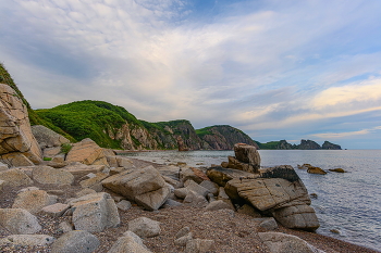 У Четырех скал / Берега южней мыса Четырех скал. Сам мыс на горизонте у правого края. Почти в центре, на фоне скальных стен - кекур Молящаяся королева. 08.23
