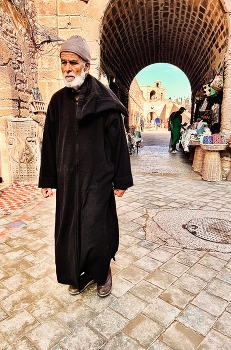 At the city gates / Man in traditional Moroccan robe at the city gates