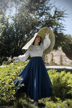 &nbsp; / A girl wearing a hat, beneath a beautiful sky, amidst nature.
