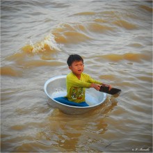 Одиночное плавание / Маленький житель поселка, стоящего прямо в воде на берегу камбоджийского озера Тонлесап, просит милостыню у иностранных туристов.