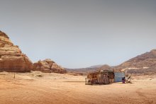 Блага цивилизации. Семейное фото. / В голой пустыне у весьма не бедного бедуина, имеющего свои &quot;кафе&quot;, в которых кормят туристов и парк строительной техники, живут три семьи. Жены располагаются друг от друга в радиусе, примерно, километра. И дети и жена обитают вот в таких лачугах. Дети за проволочной оградой. Ещё в этой хибаре с ними обитает ишак.
Вот такая цивилизация в 2011.