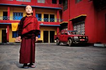 Monk in Red / Young Buddhist monk stands on the square in front of the monastery in Kathmandu, Nepal