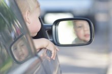 един в трёх лицах / ребёнок, смотрящийся в зеркало автомобиля