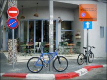 велостоянка у кафе / Тель-Авив // Надпись на оранжевой табличке &quot;Стоянка запрещена&quot;.