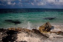 Карибы / Ласковое море резвится и играет у скалистого берега в Канкуне.