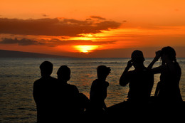 Sundowner zum Sonnenuntergang / Eine Gruppe jugendlicher beim Sonnenuntergang vor dem Hard Rock Cafe in Lahaina, Maui. Hawaii
