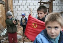 игра в прошлое / дети играют с советским флагом в заброшенном доме.