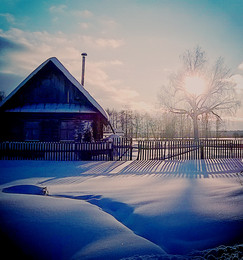 Зимнее солнце / Деревенский дом с забором и солнце в ветвях дерева.