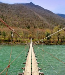 Верёвочный висячий мостик / Трудно проходить по верёвочному мостику, качающемуся над горной рекой Бзыбь.