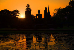 Закат у древнего храма. Сукхотай, Таиланд / Скульптура сидящего Будды и руины древнего буддистского храма на фоне заката. Сукхотай, Таиланд