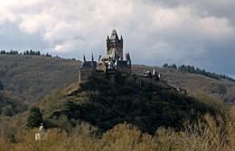 Замок Кохем / Замок Кохем (нем. Reichsburg Cochem) — бывший имперский замок в немецком городе Кохем на реке Мозель в федеральной земле Рейнланд-Пфальц.
Типичный высотный замок, расположенный на труднодоступной возвышенности, что могло быть большим преимуществом в случае опасности. Четверо ворот, расположенные друг за другом, мощные стены и рвы должны были обеспечить замку надежную защиту. Последним убежищем для защитников являлась мощная 40-метровая башня; толщина её стен в верхней части составляет 1,80 м, в нижней — 3,50 м. Её возраст около 1000 лет.