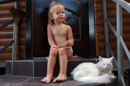 Посиделки / Внучка Полинка 2.5 года с глухой кошкой альбинос Мусей на крыльце дома.