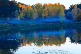 осенние краски природы! / дым от костра стелется отражением в озере.