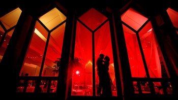 &nbsp; / Couple standing and kissing in Front of a red window