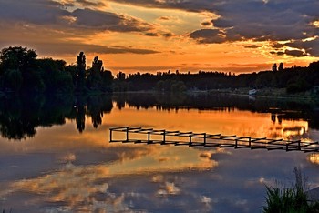 Персиком нежным закат догорает.... / Персиком нежным закат догорает,
Облака росчерк пурпурный на нём,
Как радуга небо пред ночью пылает,
Цвета переходят друг в друга огнем.
Кромочка неба -- как золота слиток,
Полоска пошире -- румянец щеки,
И зелень в синюю бездну вплетает,
Как будто забрав все цвета у реки.
А в вышине фиолетовым бархатом
Небесный шатер с Луной-серебром,
Жемчужины звёзд слагают орнаменты
Зодиакальным парчовым шитьем…
(Елена Михальченко)