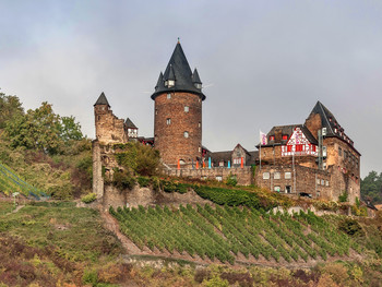Замок Шталек / Замок Шталек ( немецкий : Burg Stahleck ) - укрепленный замок 12-го века в долине Верхнего Среднего Рейна в Бахарахе в Рейнланд-Пфальце , Германия . Он стоит на скале примерно в 160 метрах (520 футов) над уровнем моря на левом берегу реки в устье долины Стиг, примерно в 50 километрах (31 милях) к югу от Кобленца , и предлагает превосходный вид на Лорелея долина. Его название означает «неприступный замок на скале», от средне-высокого немецкого слова Stahel(сталь) и эке (здесь: скала). У этого есть заполненный водой частичный ров , редкость в Германии. Построенный по приказу архиепископа Кельна , он был разрушен в конце 17-го века, но восстановлен в 20-м и в настоящее время является общежитием .