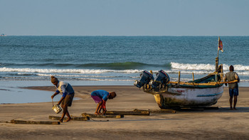 Традиции. /Рыбаки вытаскивают лодку на берег./ / Ашвем. Гоа. Индия.