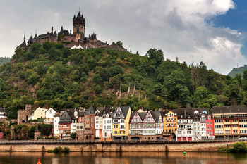Замок Райхсбург — символ немецкого города Кохем / Кохем – немецкий город, расположенный на реке Мозель. Ближайшие крупные города – Трир (77 км), Кобленц (53 км), Бонн (91 км), Франкфурт-на-Майне (150 км). Расстояние до границы с Люксембургом и Бельгией составляет 110 км. Кохем является частью земли Рейнланд-Пфальц. Население – всего 5000 человек (это один из самых маленьких городков в Германии по количеству проживающих людей). Площадь города – 21,21 км². Кохем делится на 4 городских района.
