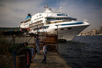 Слои общества / Бедные рыбаки ловят рыбу на фоне богатого круизного лайнера в Стамбуле.