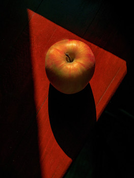 яблоко на красном столе / яблоко лежит на красном столе
