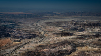 Отджинджанге и горы Хартманна / Сухое русло реки Отджинджанге пролегает среди горного массива Хартманна на Северо-Западе Намибии. Это безводная местность, лишенная жилья и дорог. Жизнь здесь застыла в ожидании дождя, которого не было несколько лет.