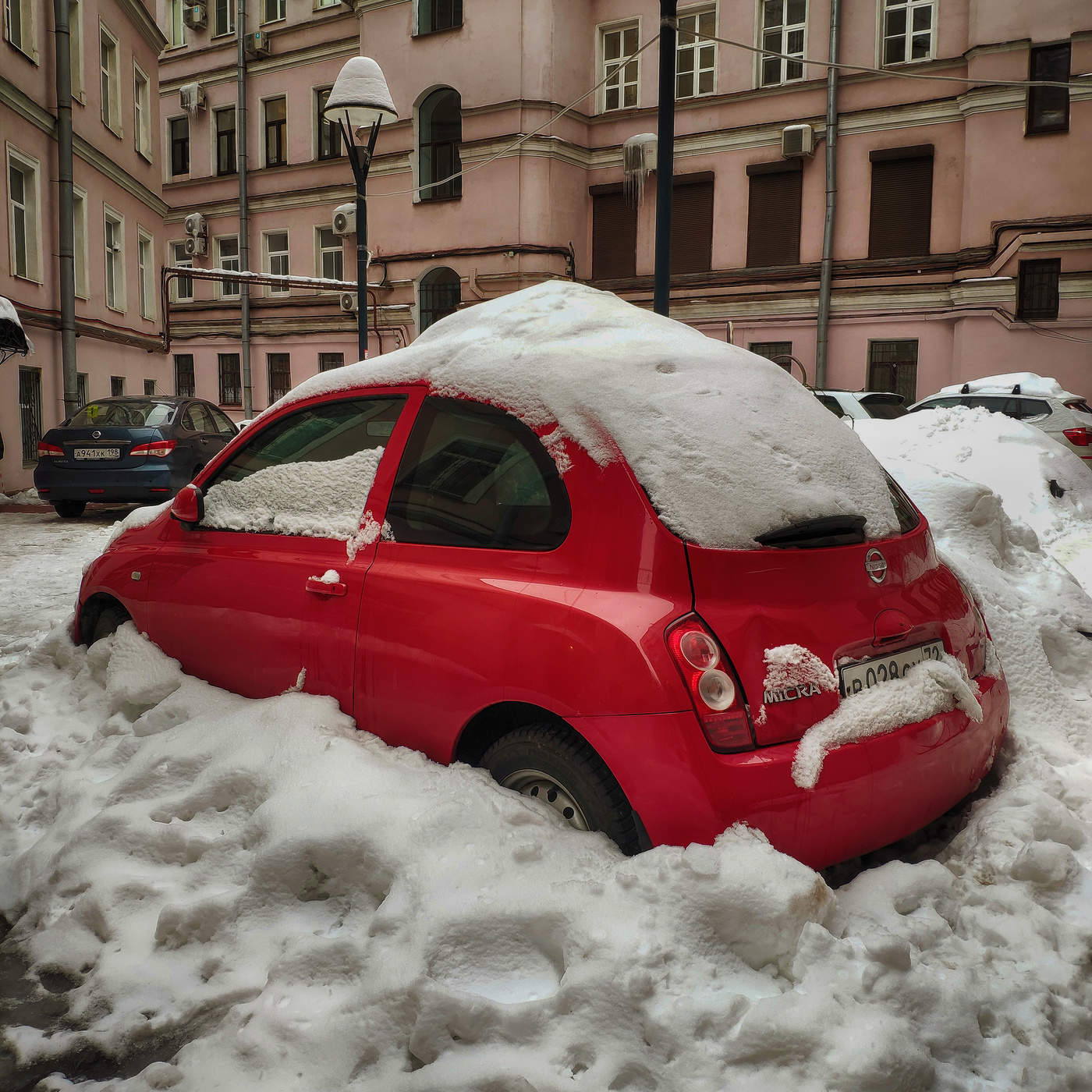 На панели красная машинка. Красная машинка. Машинка красная в снегу. Красная машинка зимой. Красный автомобиль зима город.